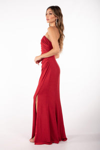 Side image of shimmer red maxi dress featuring asymmetrical one shoulder neckline, a bodycon fit with gathering detail at the front and thigh-high leg slit