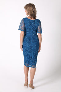 Back image of mature woman sequin cocktail dress with V neckline and butterfly sleeves in teal color