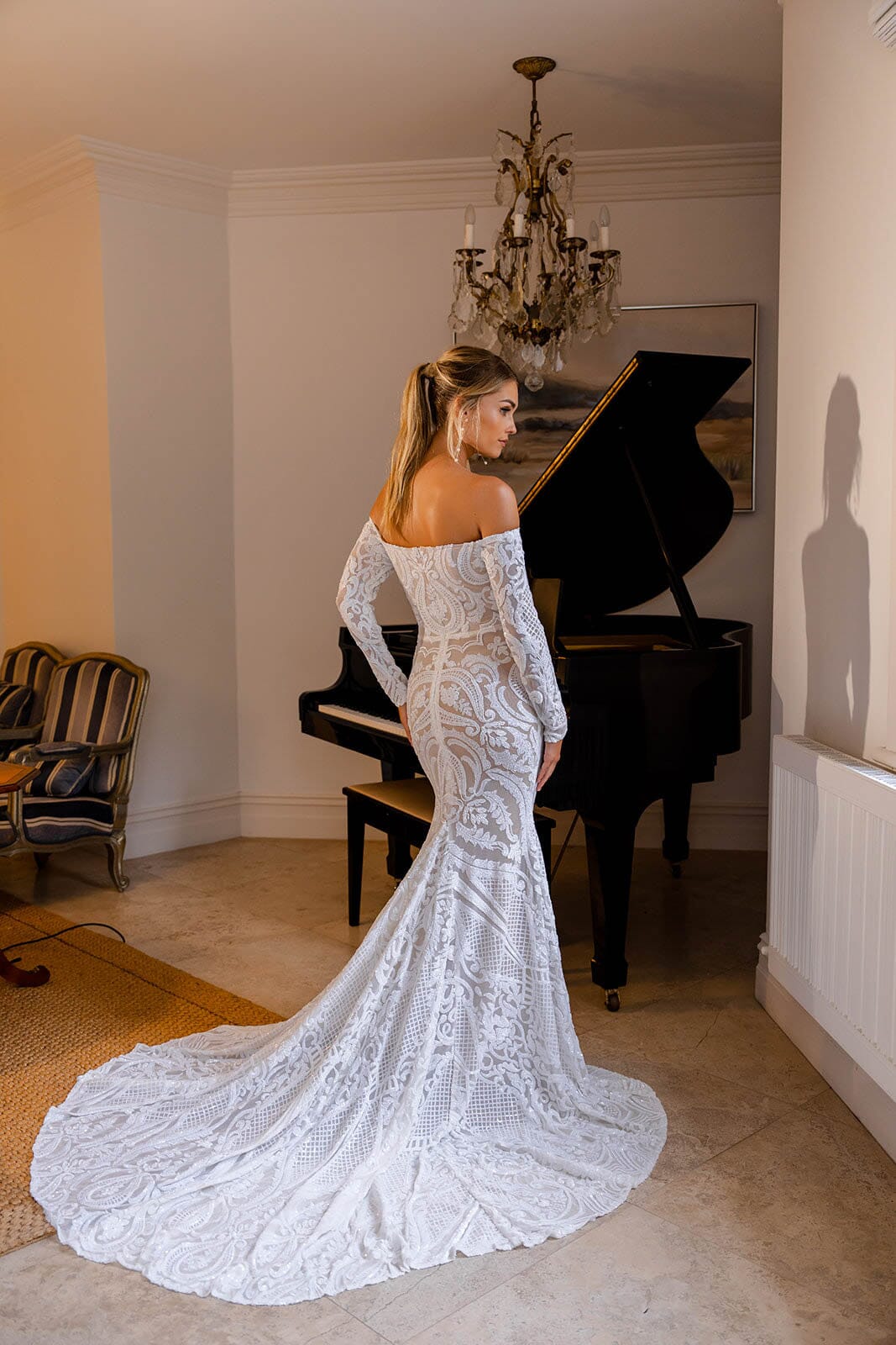 Back Image showcasing moderately long train of Nude Illusion Fitted Wedding Dress with Off-Shoulder Long Sleeves in White Pattern Sequin and Nude Underlay