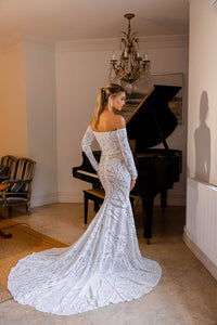 Back Image showcasing moderately long train of Nude Illusion Fitted Wedding Dress with Off-Shoulder Long Sleeves in White Pattern Sequin and Nude Underlay