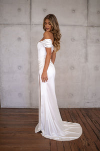 Side image of white off-shoulder fitted wedding dress with a high slit and moderate train
