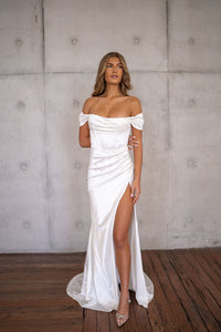 White off-the-shoulder fitted wedding dress with draped detail and a high slit