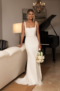 Bride holding a white rose bouquet wearing White Embellished Beaded Sequin Wedding Gown with Square Neckline and Form-Fitting Silhouette