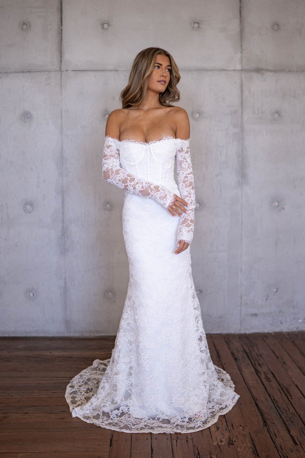 Sheer Sleeves of Ivory White Off The Shoulder Long Sleeve Lace Wedding Gown with Sweetheart Neckline, Corset Bodice and Fit and Flare Mermaid Silhouette