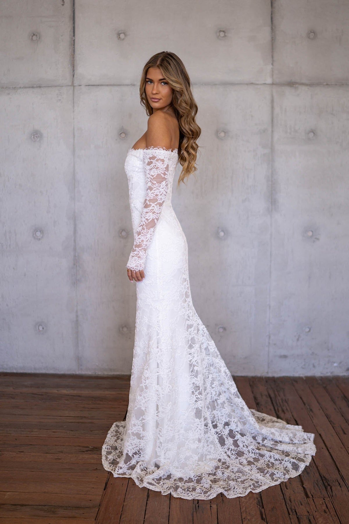 Side Image of Ivory White Off The Shoulder Long Sleeve Lace Wedding Gown with Sweetheart Neckline, Corset Bodice and Fit and Flare Mermaid Silhouette