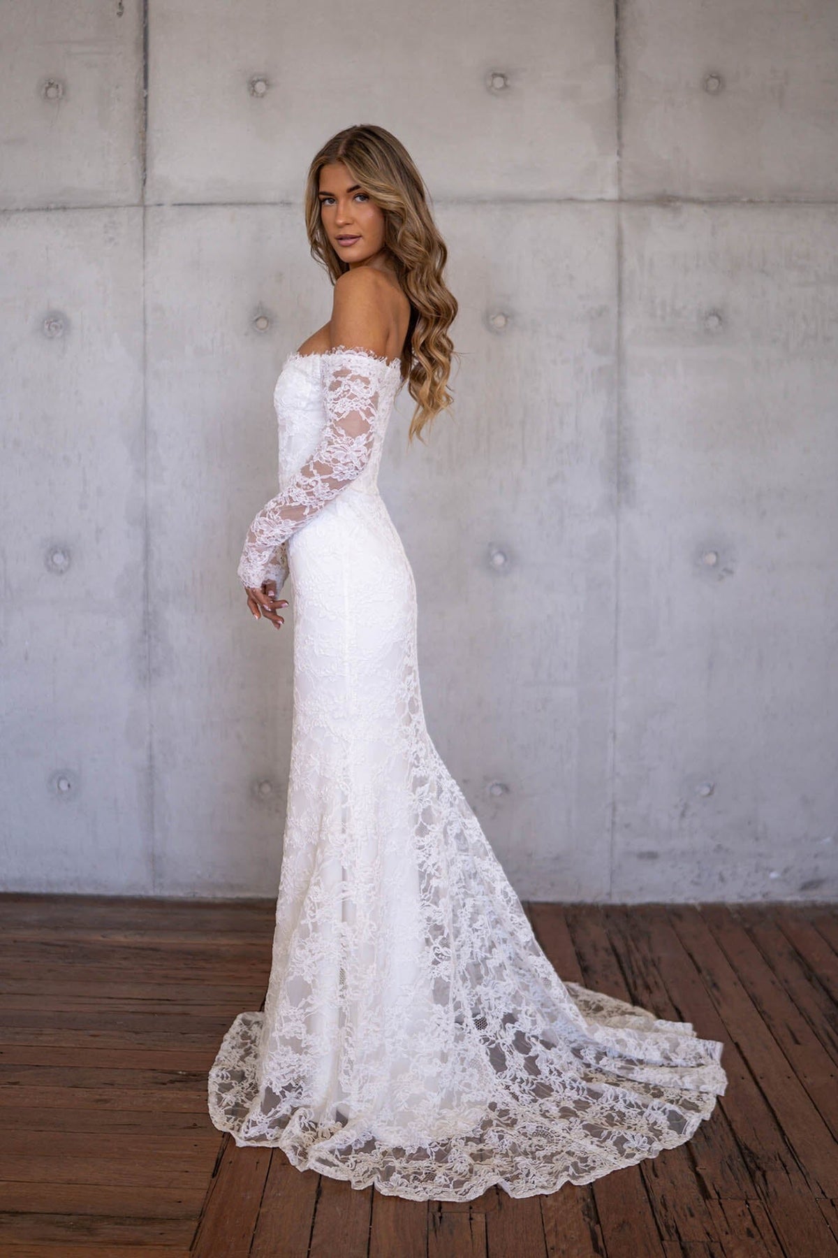Sheer Sleeve of Ivory White Off The Shoulder Long Sleeve Lace Wedding Gown with Sweetheart Neckline, Corset Bodice and Fit and Flare Mermaid Silhouette