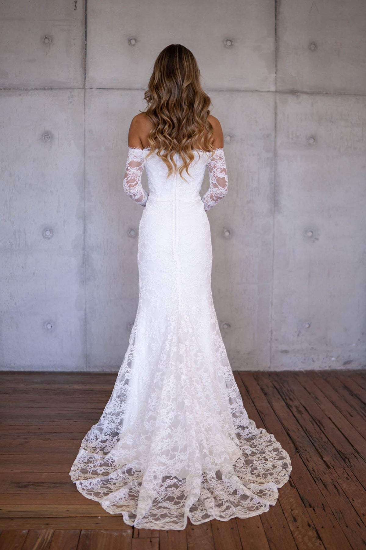 Back Image and Sweep Train of Ivory White Off The Shoulder Long Sleeve Lace Wedding Gown with Sweetheart Neckline, Corset Bodice and Fit and Flare Mermaid Silhouette