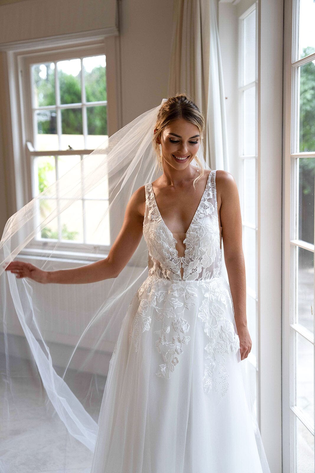 Ivory White A-line Wedding Gown with V Neckline adorned with Lace Appliques, Sheer Bodice and Full Voluminous Layered Tulle Skirt