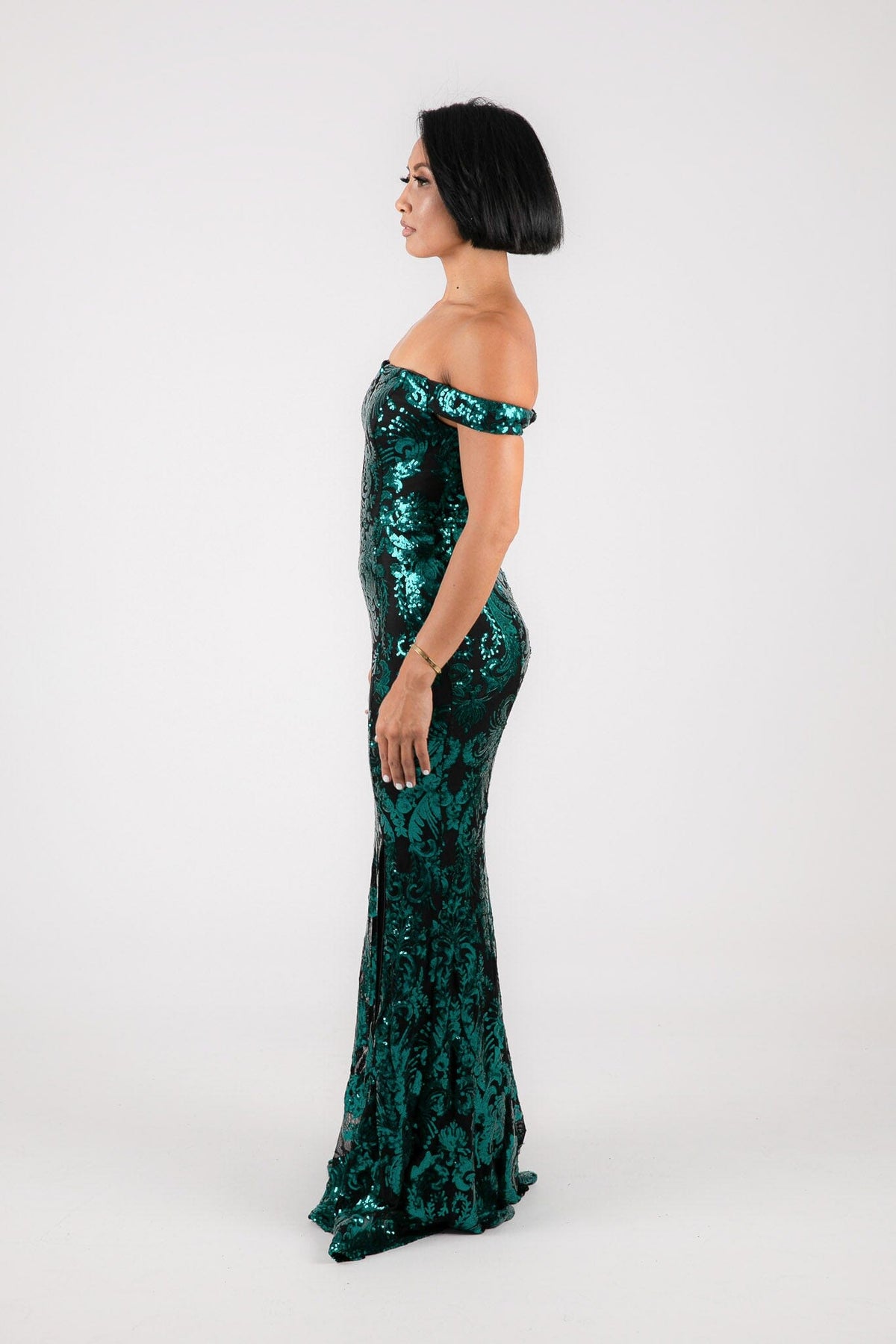 Side Image of Emerald Green Sequins with Black Underlay Off Shoulder Full Length Maxi Dress with V Cut Out Neckline Detail and Slit on the Left Leg