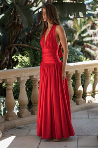 Side image of SIENNA red Christmas party backless maxi dress featuring a ruched waist and flowing skirt in premium stretch jersey
