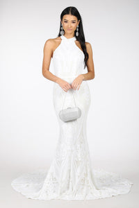 White Pattern Sequin Gown with High Neck and Fit and Flare Mermaid Skirt Styled with Silver Drop Earrings and Silver Clutch Bag