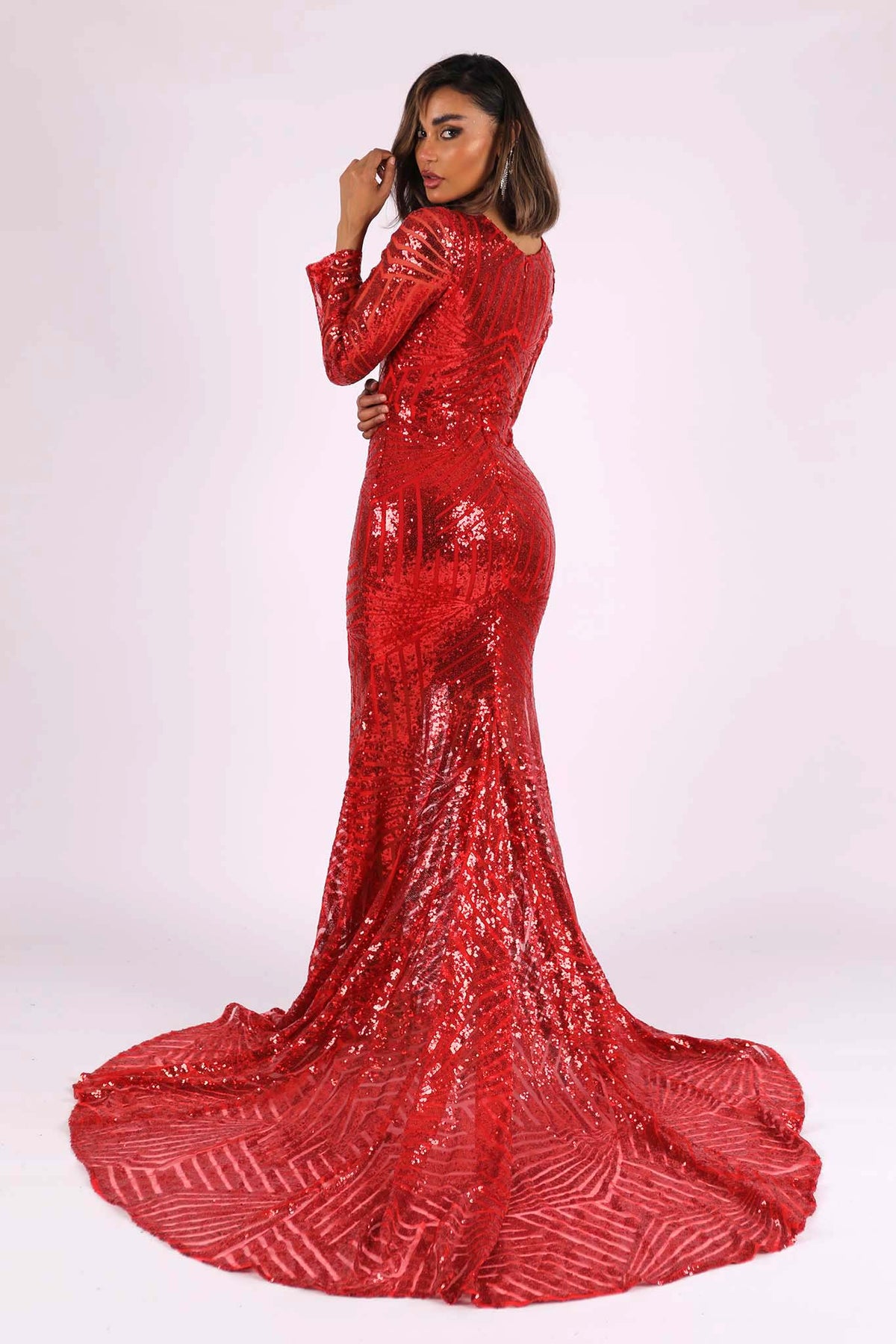 Closed back and long trail design of red long sleeve geometric pattern sequin full length evening gown with V plunge neckline, center front slit and floor sweeping train