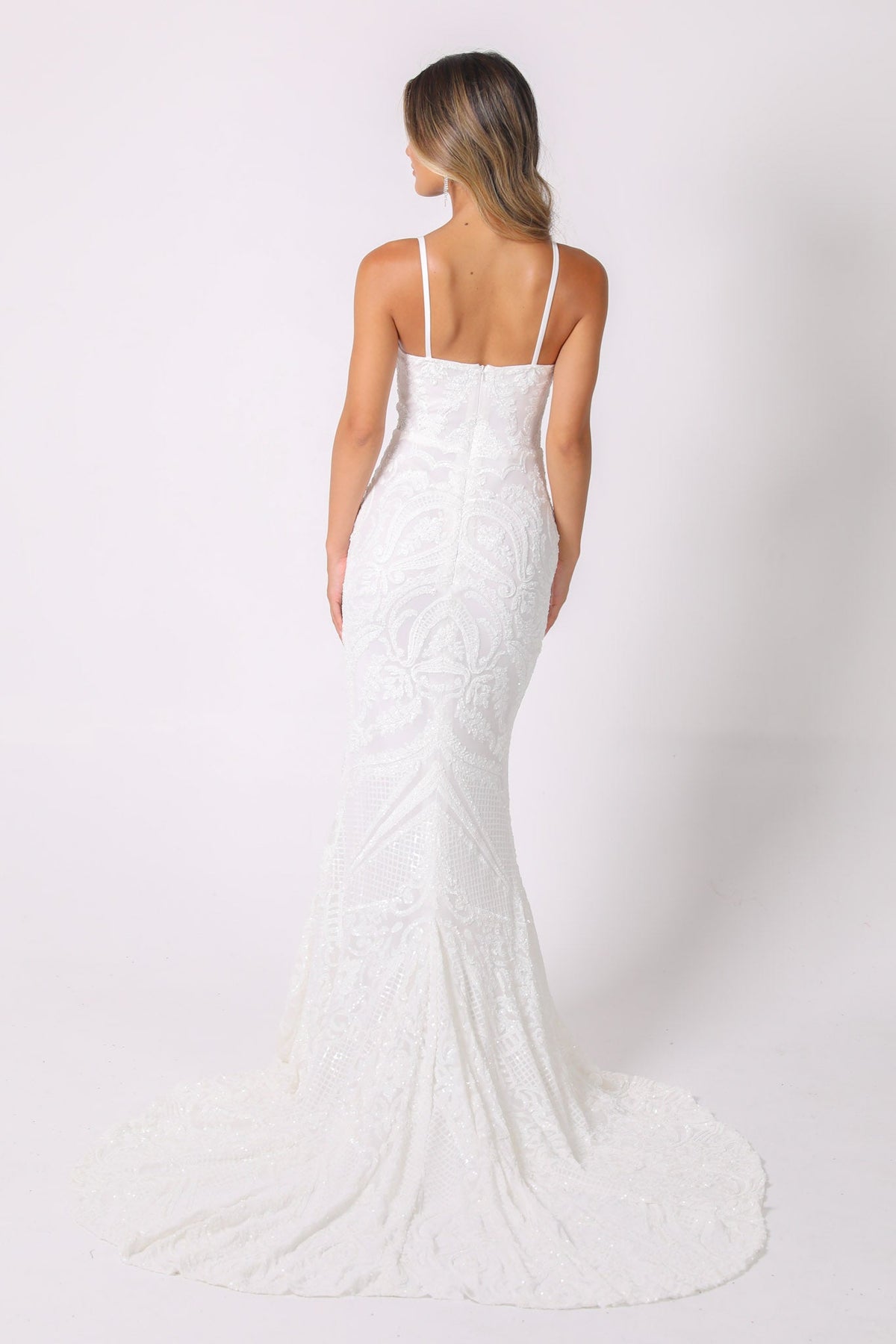 Back and sweep train of white embroidered pattern sequin gown with sweetheart neckline and thin shoulder straps