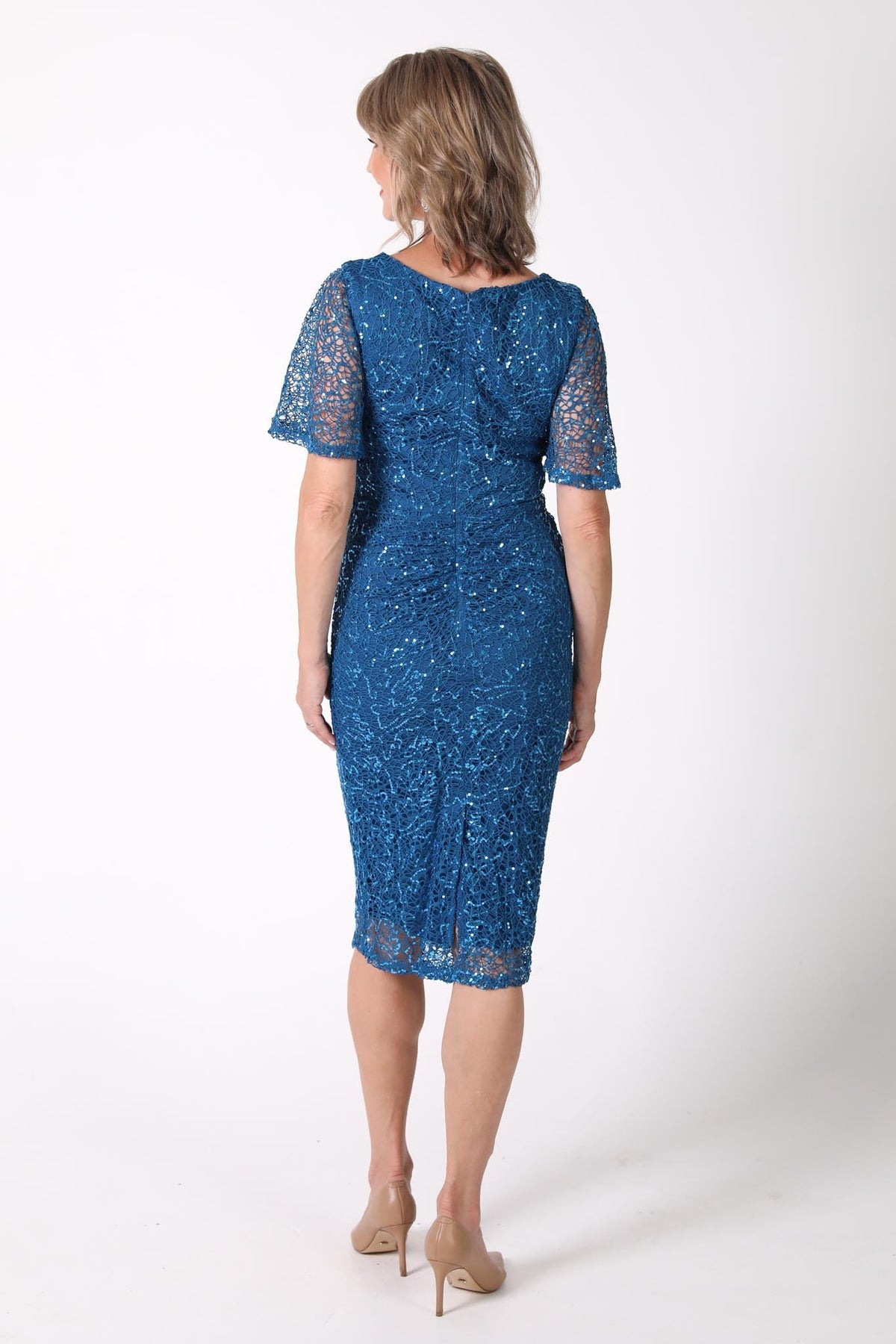 Back image of mature woman sequin cocktail dress with V neckline and butterfly sleeves in teal color